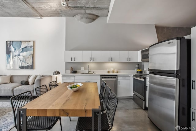 300 Beale St Unit 504, San Francisco, CA 94105 - kitchen featuring stainless steel appliances, finished concrete flooring, light countertops, and white cabinetry