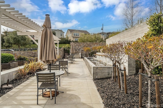 view of patio with a vegetable garden, fence, and a pergola