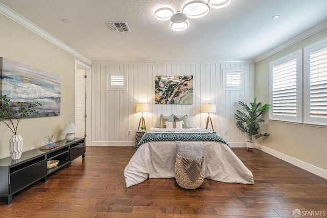 bedroom featuring baseboards, visible vents, wood finished floors, and ornamental molding