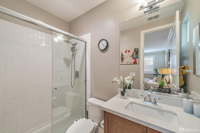 full bath with visible vents, a textured wall, toilet, a shower stall, and vanity