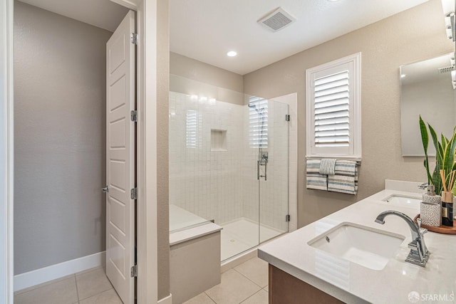 full bathroom featuring a stall shower, visible vents, baseboards, tile patterned flooring, and a sink