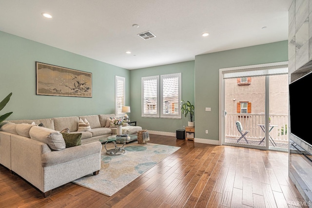 living area featuring recessed lighting, wood finished floors, visible vents, and baseboards