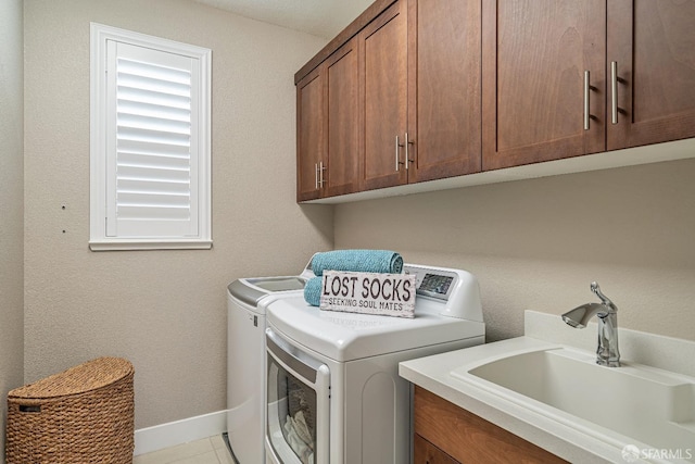 laundry area with cabinet space, baseboards, a sink, and independent washer and dryer