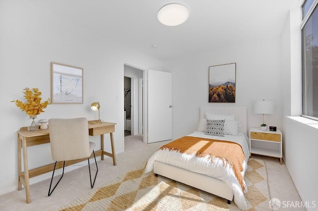 carpeted bedroom featuring an office area and baseboards