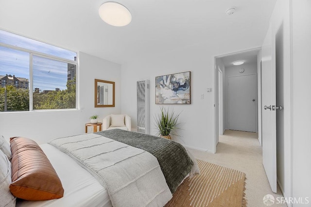 bedroom with a heating unit and light carpet