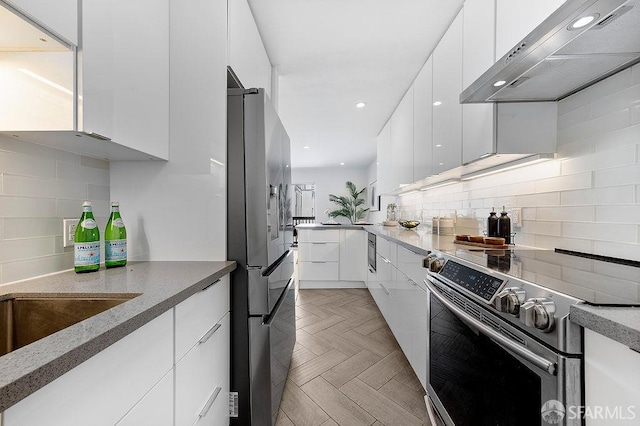 kitchen featuring appliances with stainless steel finishes, extractor fan, modern cabinets, white cabinets, and recessed lighting