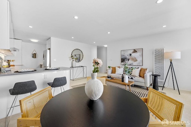 dining room with a heating unit, recessed lighting, and light carpet