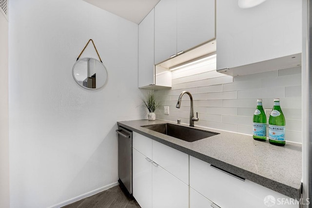 kitchen with a sink, decorative backsplash, white cabinetry, and dishwasher