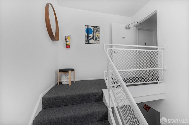 stairway featuring carpet and baseboards