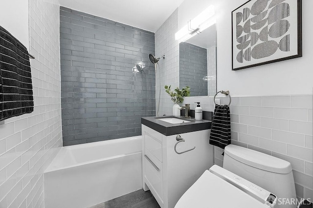 full bathroom with tile walls, toilet, bathtub / shower combination, and vanity
