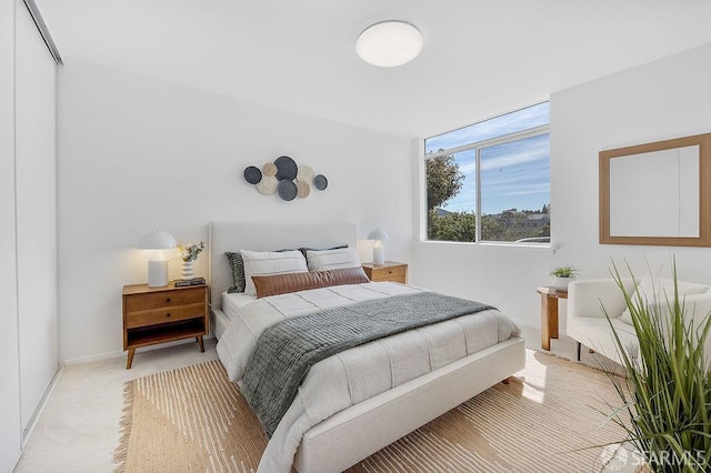bedroom with light carpet and baseboards