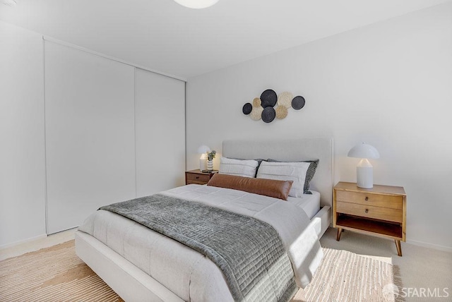 bedroom with light colored carpet and a closet