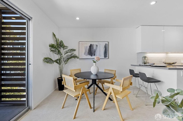dining space featuring light carpet, healthy amount of natural light, recessed lighting, and baseboards