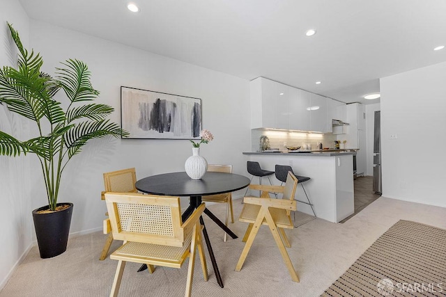 dining room with light colored carpet and recessed lighting
