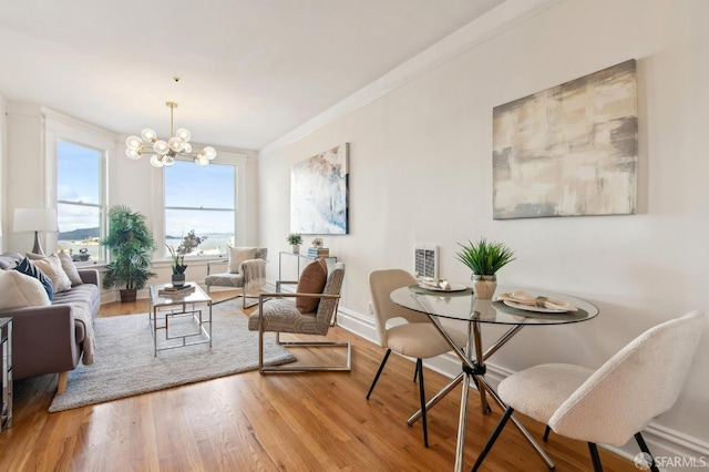 dining area featuring hardwood / wood-style flooring, crown molding, and a chandelier