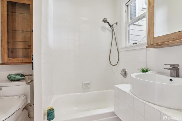 full bathroom with tiled shower / bath, sink, and toilet