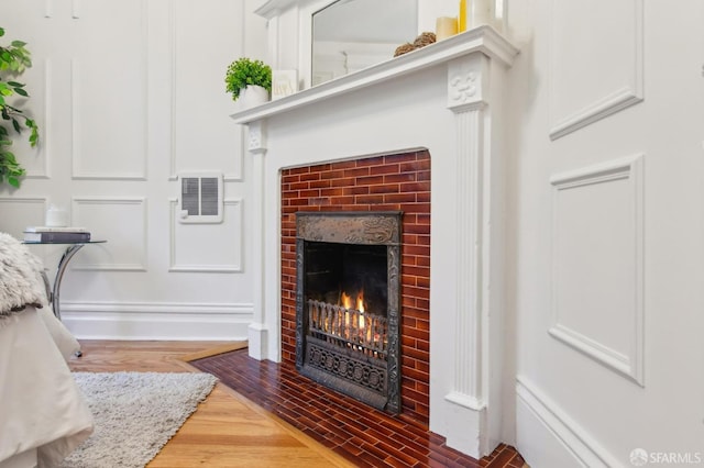 room details with a brick fireplace and wood-type flooring