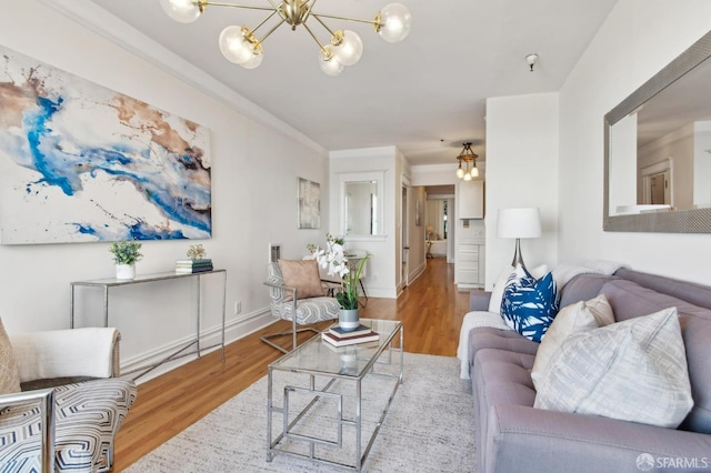 living room with an inviting chandelier, hardwood / wood-style flooring, and ornamental molding