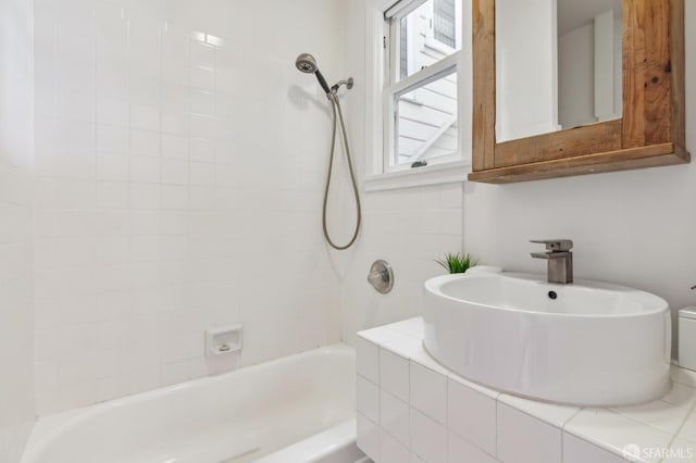 bathroom featuring sink and tiled shower / bath