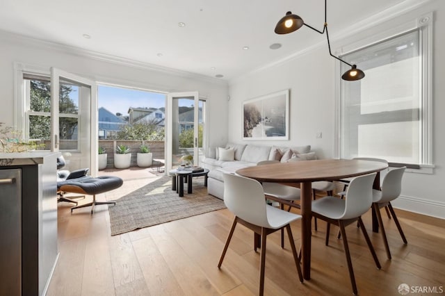 dining room with ornamental molding, hardwood / wood-style floors, and plenty of natural light
