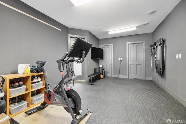 exercise room with baseboards and carpet
