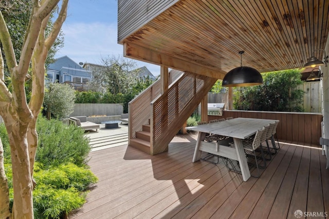 wooden deck featuring grilling area, outdoor dining space, and fence private yard