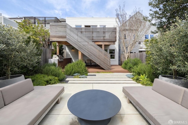view of property's community featuring stairway, a patio, outdoor lounge area, and fence