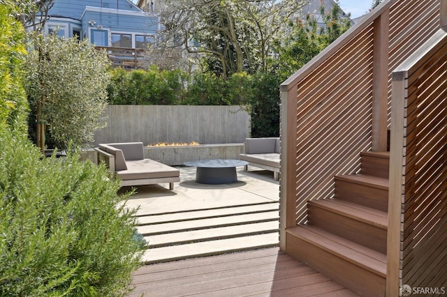 deck featuring a fire pit, a patio area, and stairway