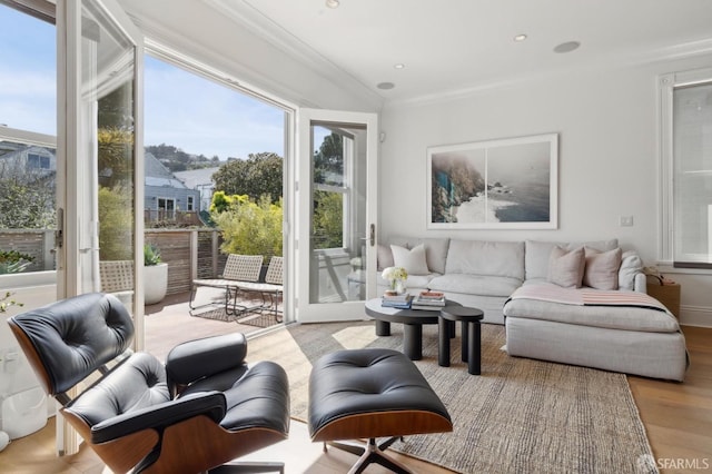 living room featuring crown molding, plenty of natural light, and wood finished floors