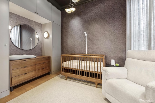 bedroom featuring a crib and wood finished floors
