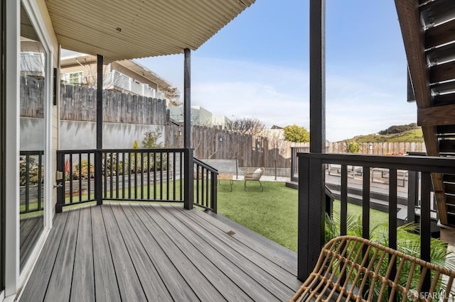 wooden deck featuring a lawn and a fenced backyard