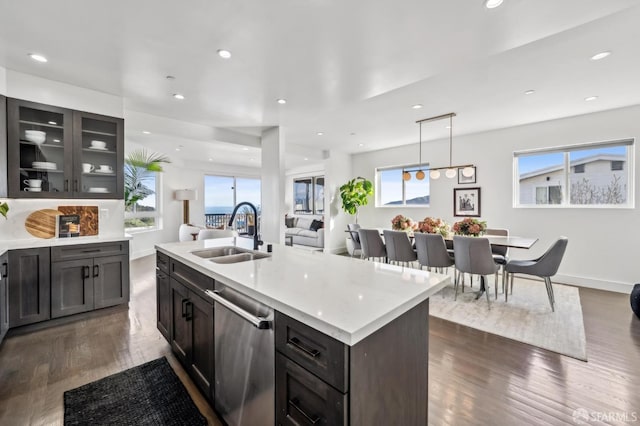 kitchen with dishwasher, light countertops, recessed lighting, dark wood-style floors, and a sink