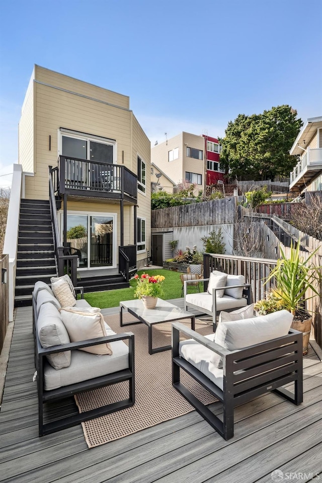 wooden deck featuring outdoor lounge area, stairs, and fence