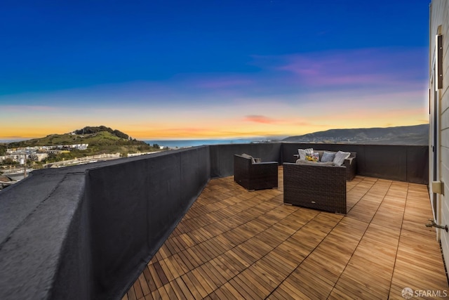 patio terrace at dusk featuring a mountain view and an outdoor hangout area