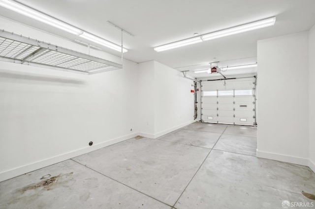 garage featuring a garage door opener and baseboards