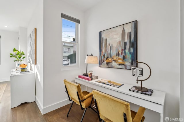 home office with wood finished floors, baseboards, and built in desk