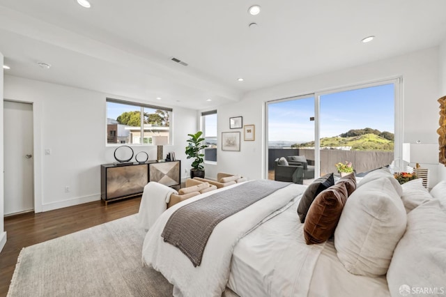 bedroom with recessed lighting, multiple windows, wood finished floors, and access to outside