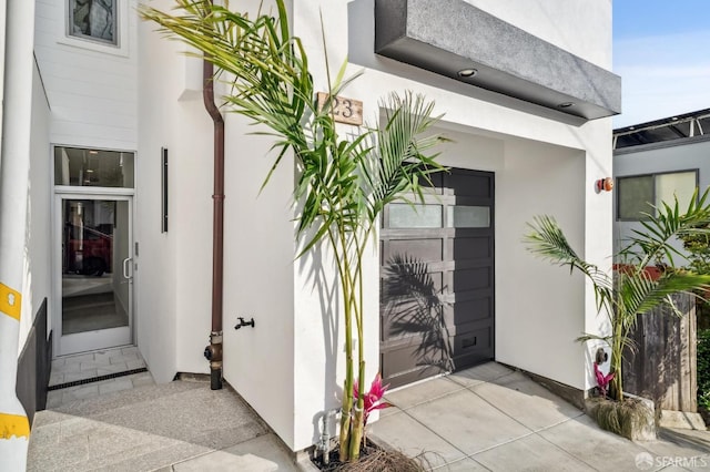 property entrance featuring stucco siding and a garage