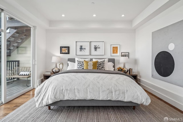 bedroom with access to exterior, recessed lighting, baseboards, and wood finished floors