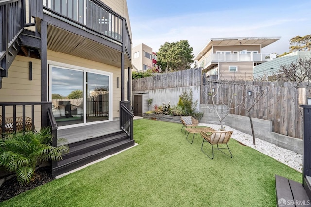 view of yard with a balcony and fence