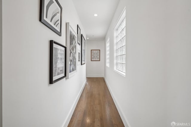 corridor featuring recessed lighting, wood finished floors, and baseboards