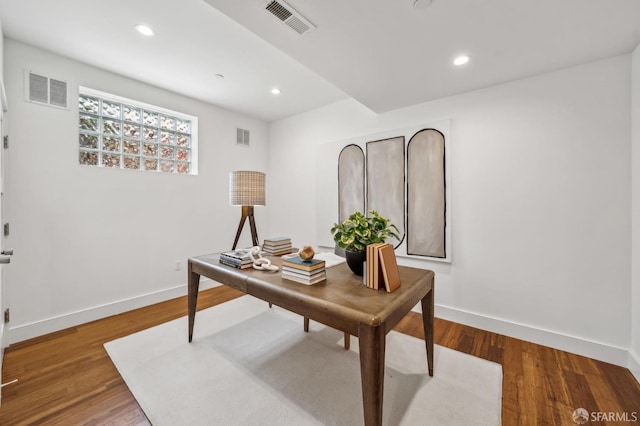 office space with visible vents, baseboards, and wood finished floors