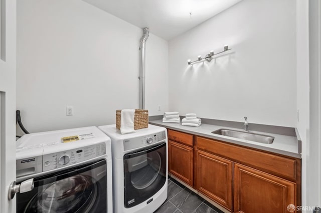 clothes washing area featuring cabinet space, washer and dryer, and a sink