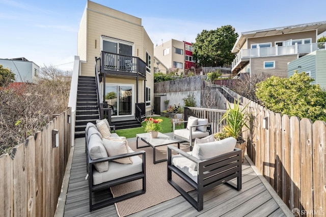 wooden terrace with stairway, an outdoor living space, and a fenced backyard