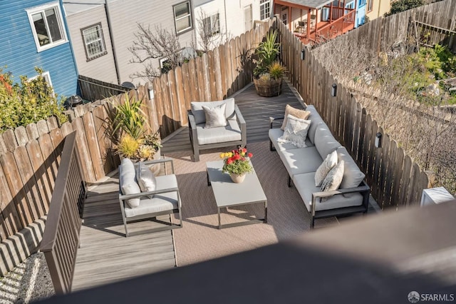 wooden deck featuring an outdoor hangout area and a fenced backyard