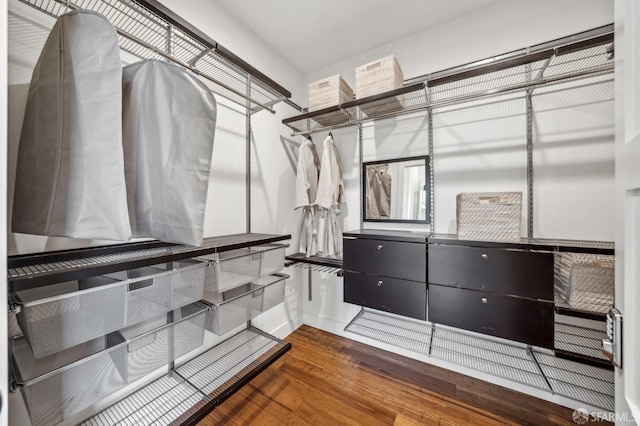 walk in closet with wood finished floors