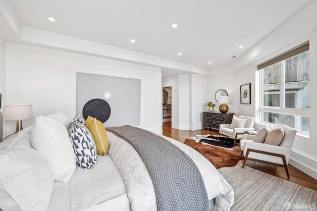 bedroom with recessed lighting, wood finished floors, and baseboards