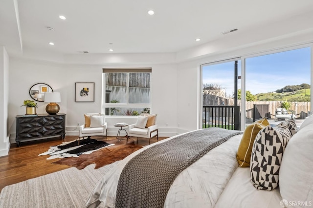 bedroom with wood finished floors, visible vents, baseboards, recessed lighting, and access to exterior