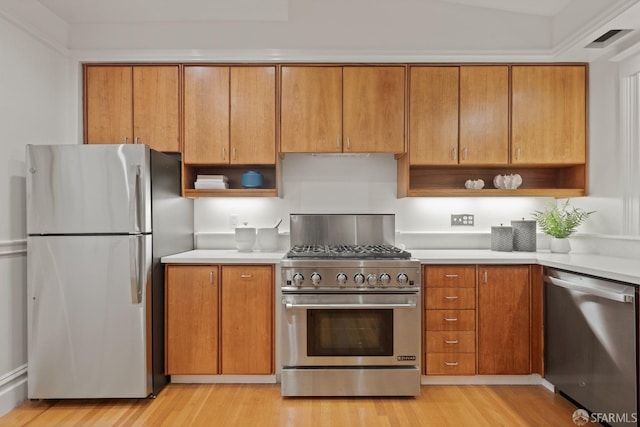 kitchen with appliances with stainless steel finishes, light countertops, light wood-style floors, and open shelves