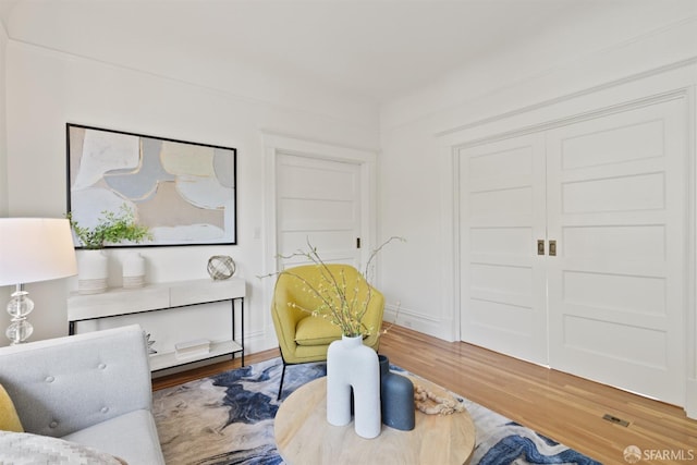 sitting room with baseboards and wood finished floors